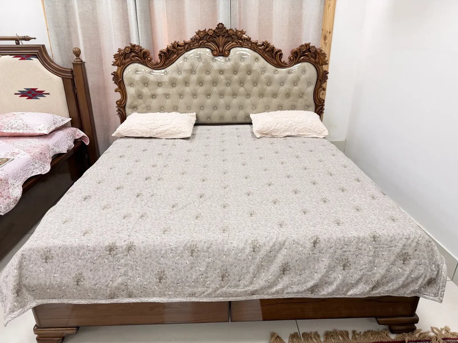 Monumental royal bed with deeply carved floral crown and deep button-tufted upholstery